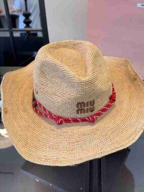 Miu Miu natural straw hat featuring a charming red braided trim.